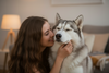 Woman hugging a Husky dog in a cozy indoor setting